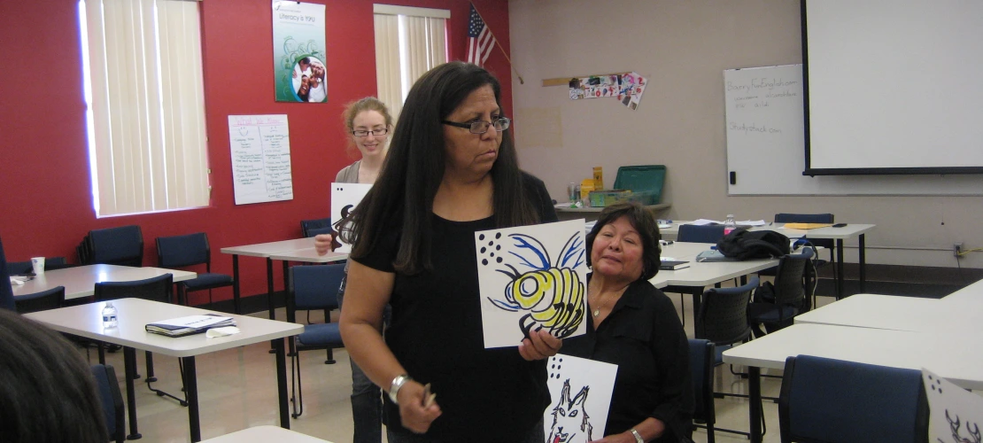 a female showing a drawing of a yellow hornet
