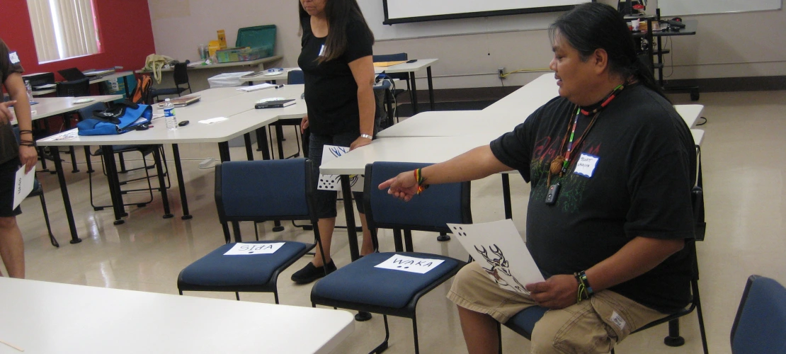 A male is pointing at a seat and a women is walking towards to it